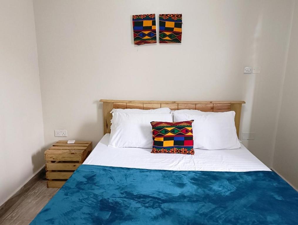 1 cama con 2 almohadas en una habitación en Amaryllis blue,8mins source to River Nile,secure, peaceful, central great location, en Jinja