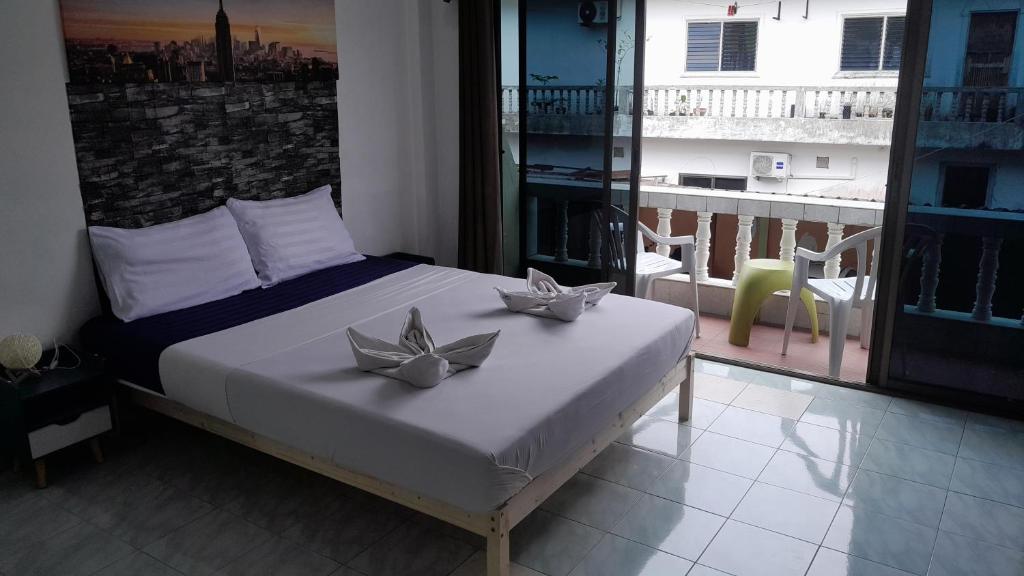 Un dormitorio con una cama con dos flores de plata. en The Guest House, en Patong Beach