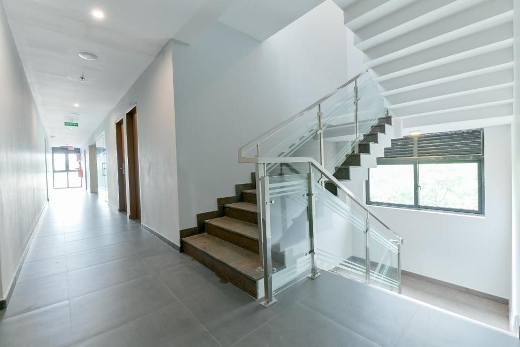 uma escada numa casa com um corrimão de vidro em Super Capital O Edassery Blue Bells em Angamaly