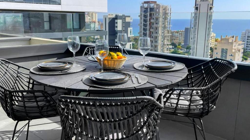 een tafel met een schaal fruit en wijnglazen op een balkon bij Apartamento de lujo Alexia 1 Calpe in Calpe