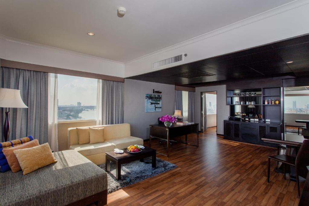 A spacious living room with a sofa, dining table and broad water view.