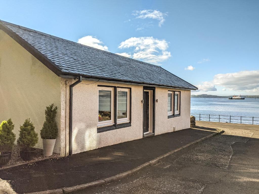 a small house with a view of the water at Strathclyde Cottage North in Skelmorlie