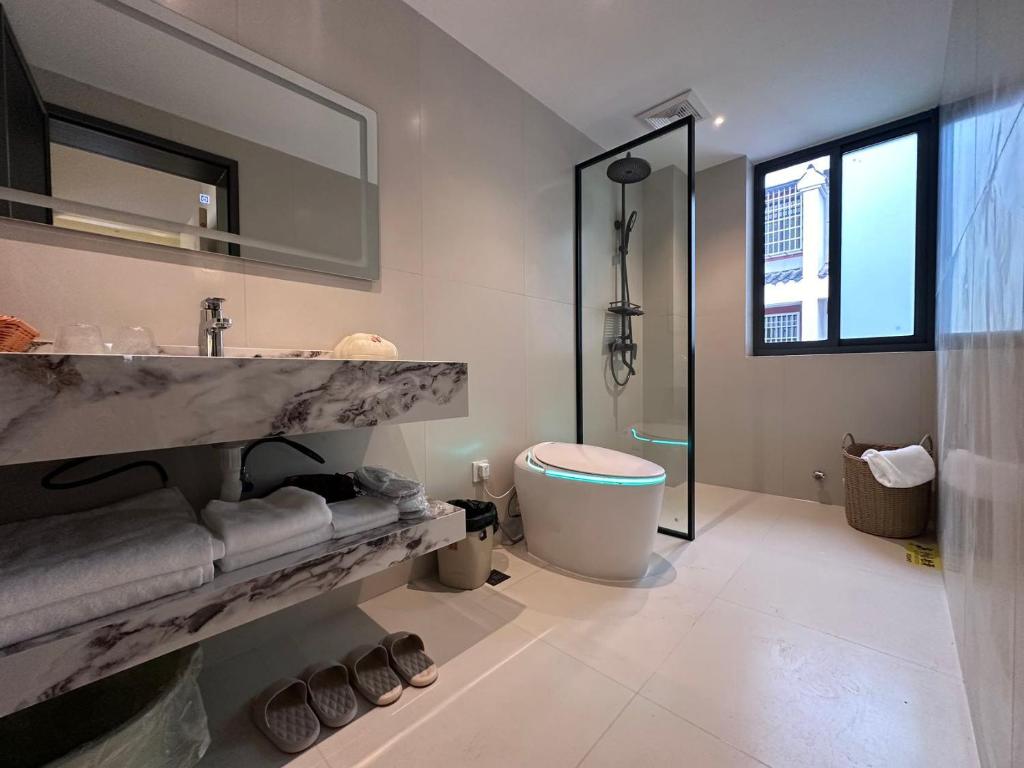 a bathroom with a sink and a toilet at Flower Whisperer Homestay Tianmenshan Store free airport and station pick-up in Zhangjiajie