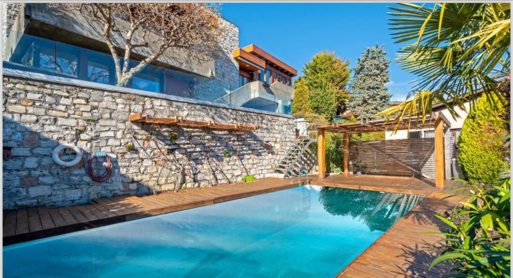 a swimming pool in front of a stone house at La Villa with heated pool and amaizing view in Cademario