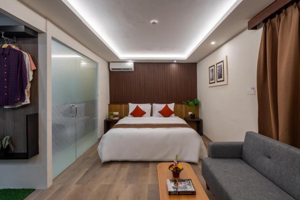 een hotelkamer met een bed en een bank bij Everyday Hotel Kuta Central in Kuta