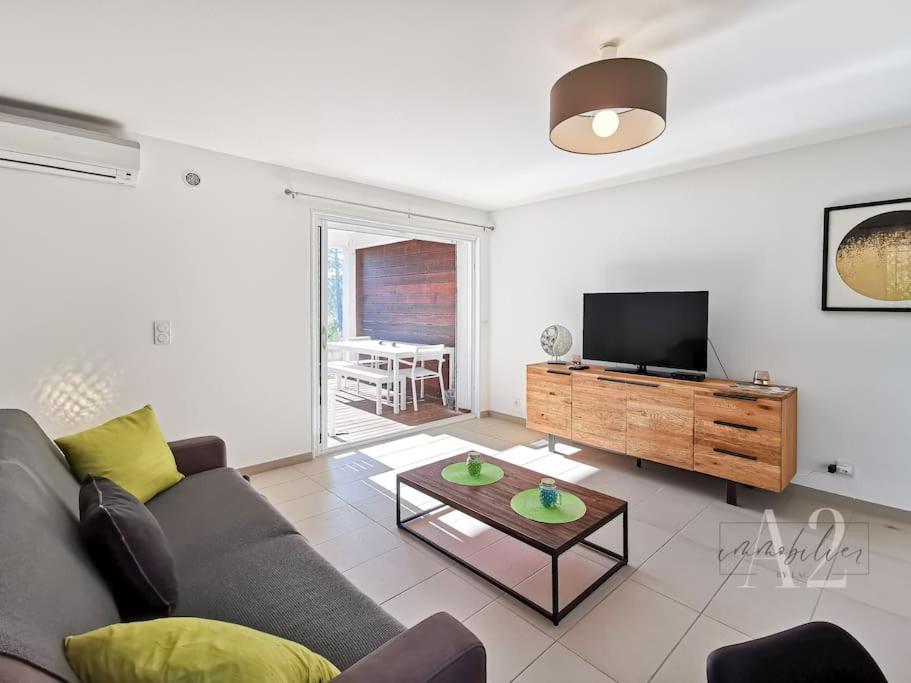 un salon avec un canapé et une télévision à écran plat dans l'établissement Appartement 4 Pers - Cala Rossa - Piscine, à Lecci