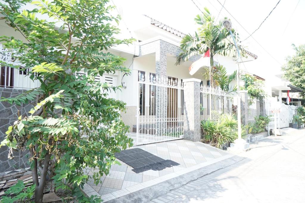 a white fence in front of a house at OYO 93710 Bidara Guest House Syariah in Mojokerto