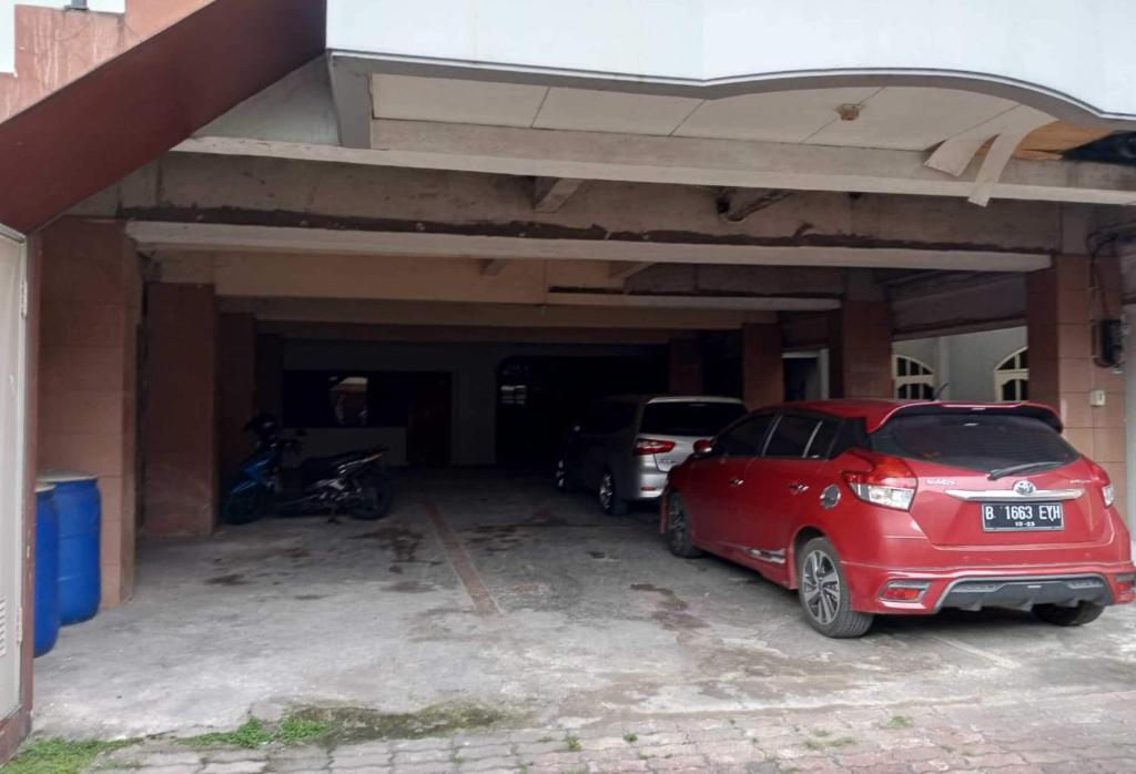 a red car is parked in a garage at OYO 93722 Shannhay Guest House in Jakarta