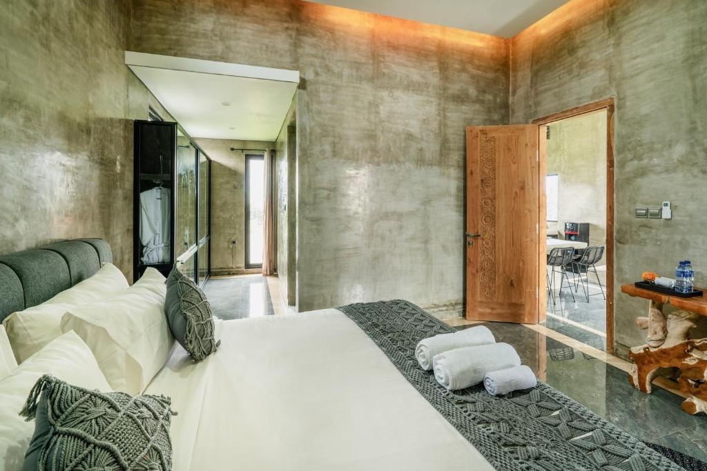 um quarto com uma grande cama branca com toalhas em Casa Jenah em Darmasaba