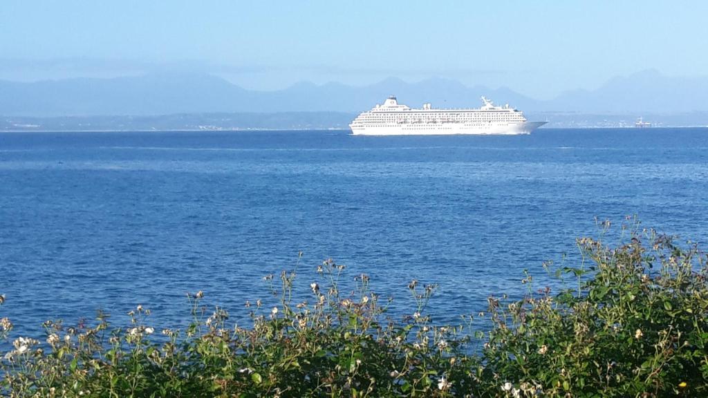 a cruise ship in the middle of the ocean at Beacon Wharf ERIN Where Ocean & Mountains Serenade in Harmony in Mossel Bay