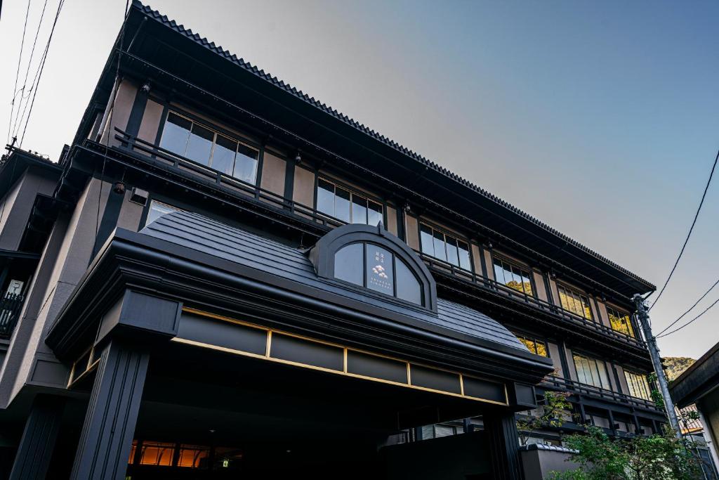 Un edificio negro con un reloj a un lado. en 深山城崎 en Toyooka
