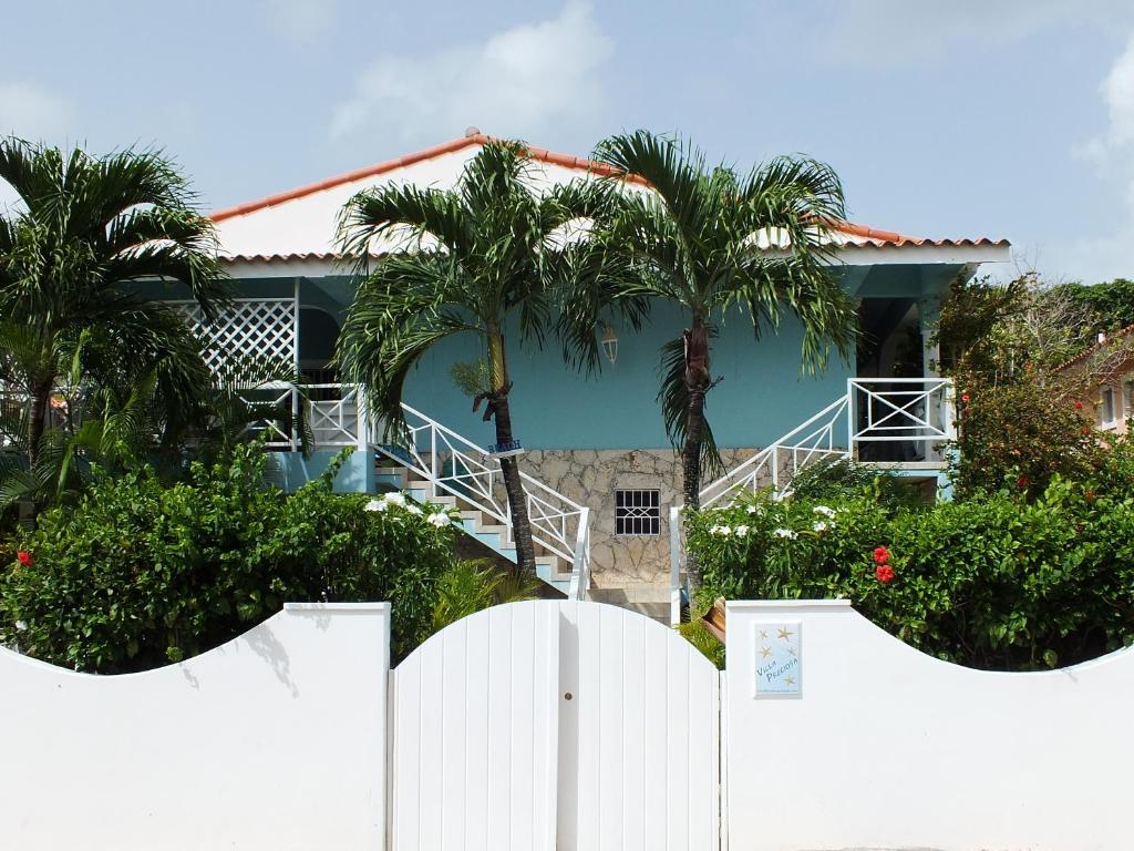 una recinzione bianca di fronte a una casa con palme di Villa Preciosa a Bayahibe