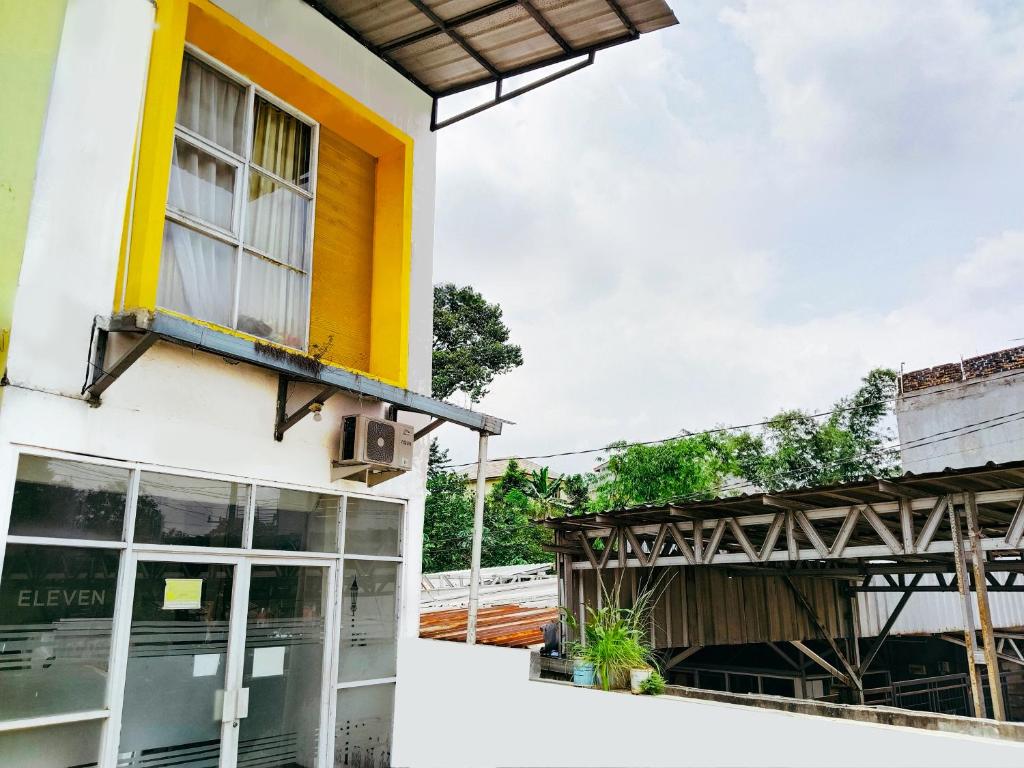 ein Gebäude mit einem gelben Fenster und einem Balkon in der Unterkunft Eleven Guest House Syariah in Sukaraja