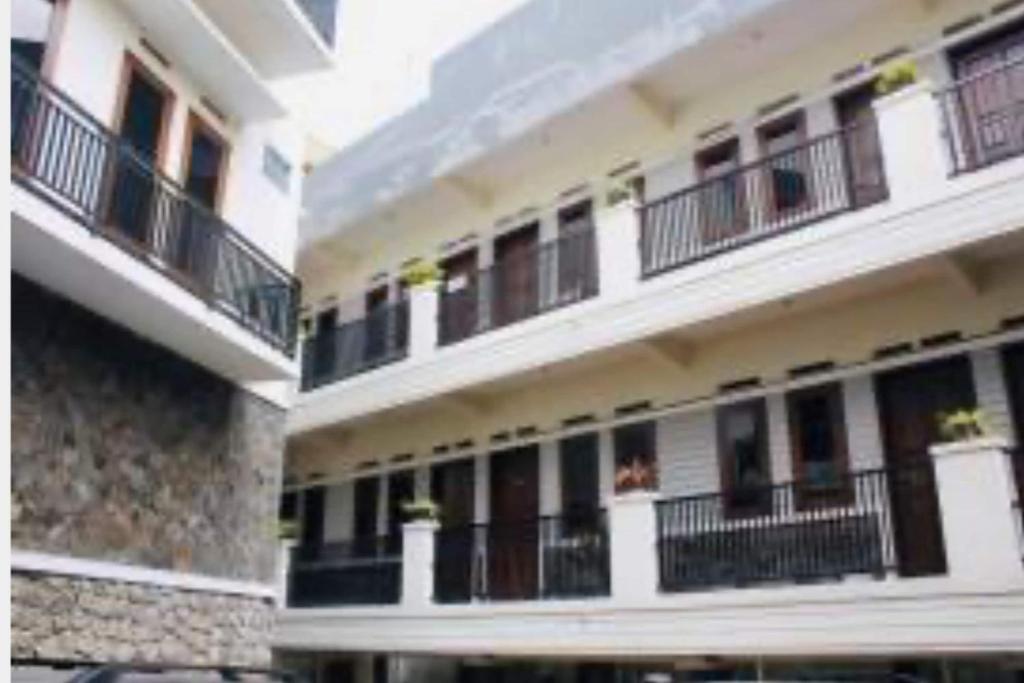 a white building with balconies and windows at OYO 93756 Qq Kost in Laleng-balandae