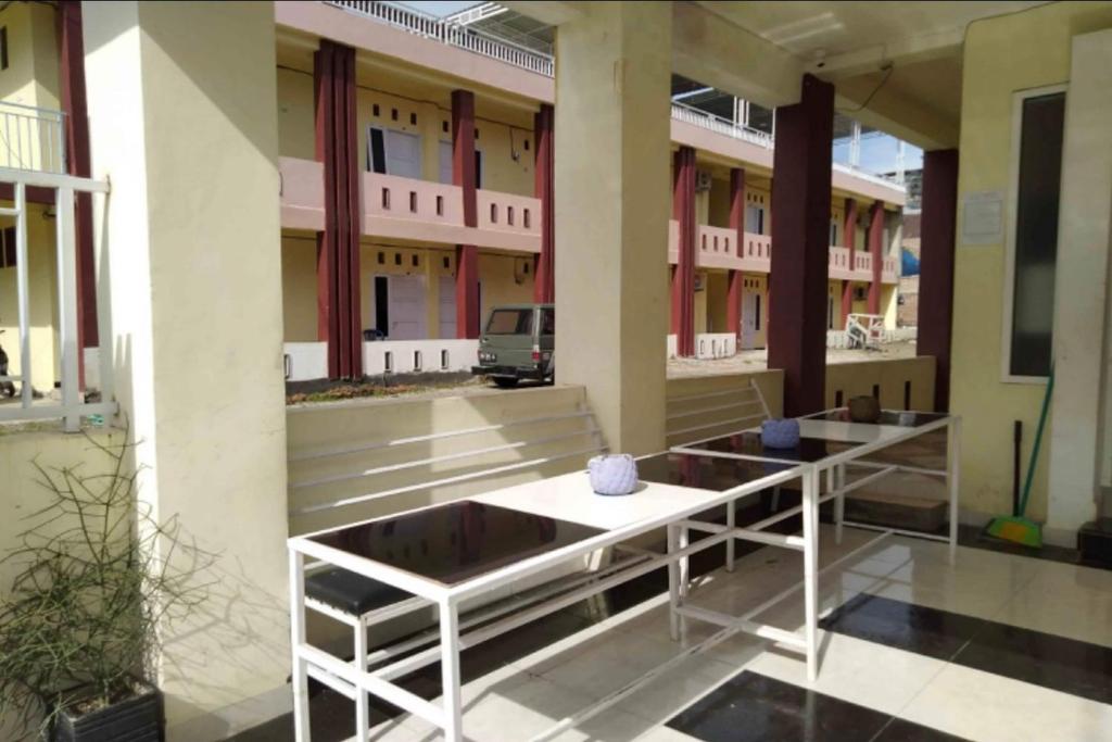 a building with two tables in front of it at OYO 93735 Pondok Zamzam in Pakato