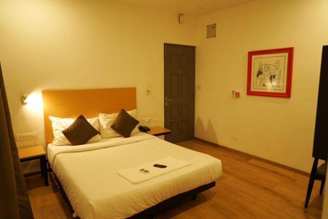 a hotel room with a bed and a door at TREETOP INN in Chennai