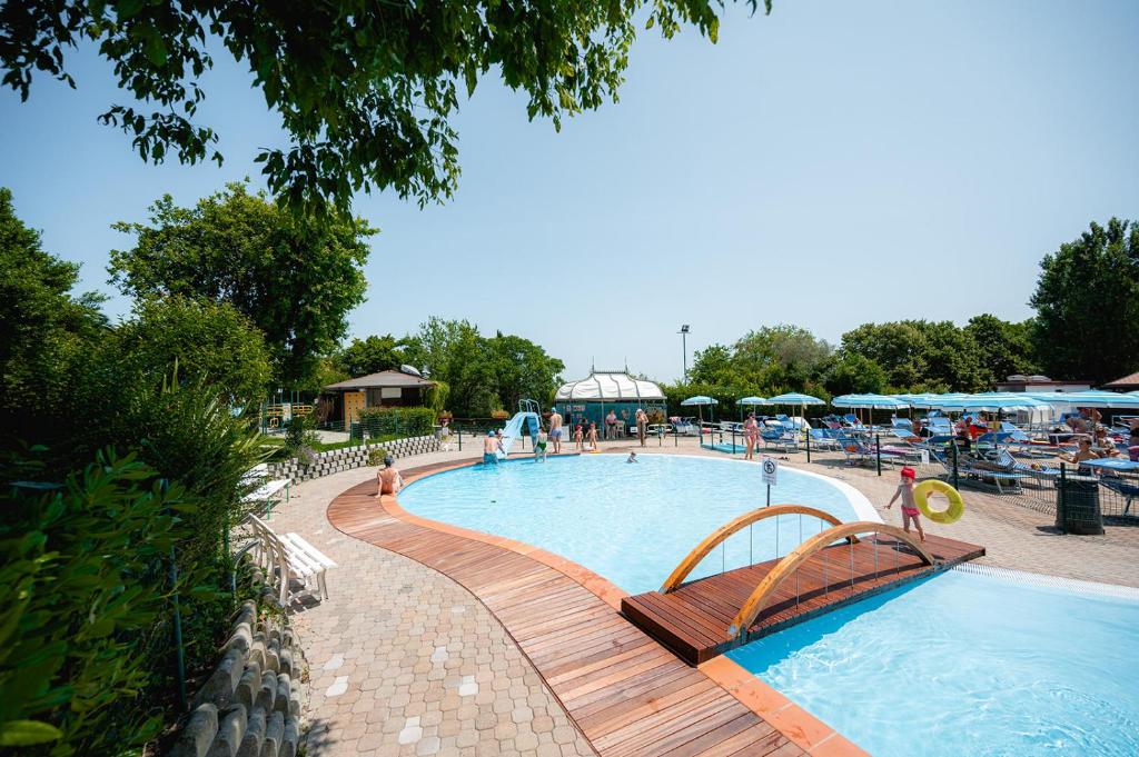 uma grande piscina com um banco de madeira ao lado em Glamping San Marino em San Marino