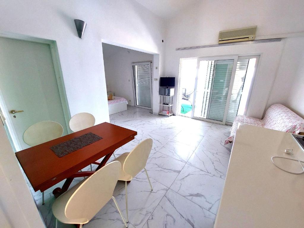 una sala da pranzo con tavolo e sedie in una stanza di Silvija Apartments a Primošten