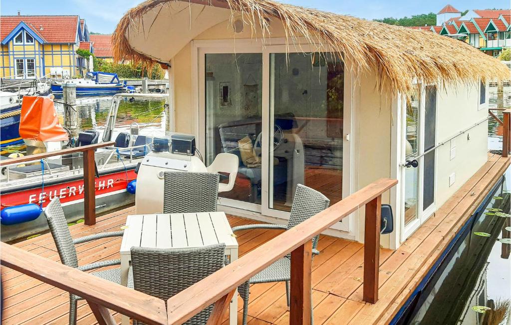 a deck with a table and chairs and a boat at Beautiful Ship In Neuruppin With Lake View in Neuruppin
