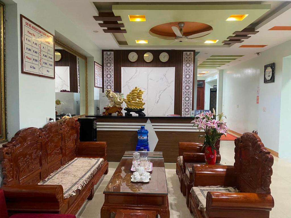 una sala d'attesa con divani, tavolo e fiori di Kim Ngân Hotel Lào Cai a Lao Cai