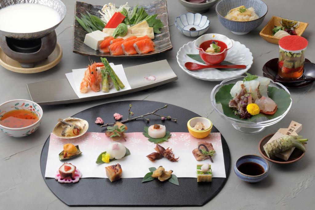 a table with many plates of food on it at Gion Ryokan Karaku in Kyoto