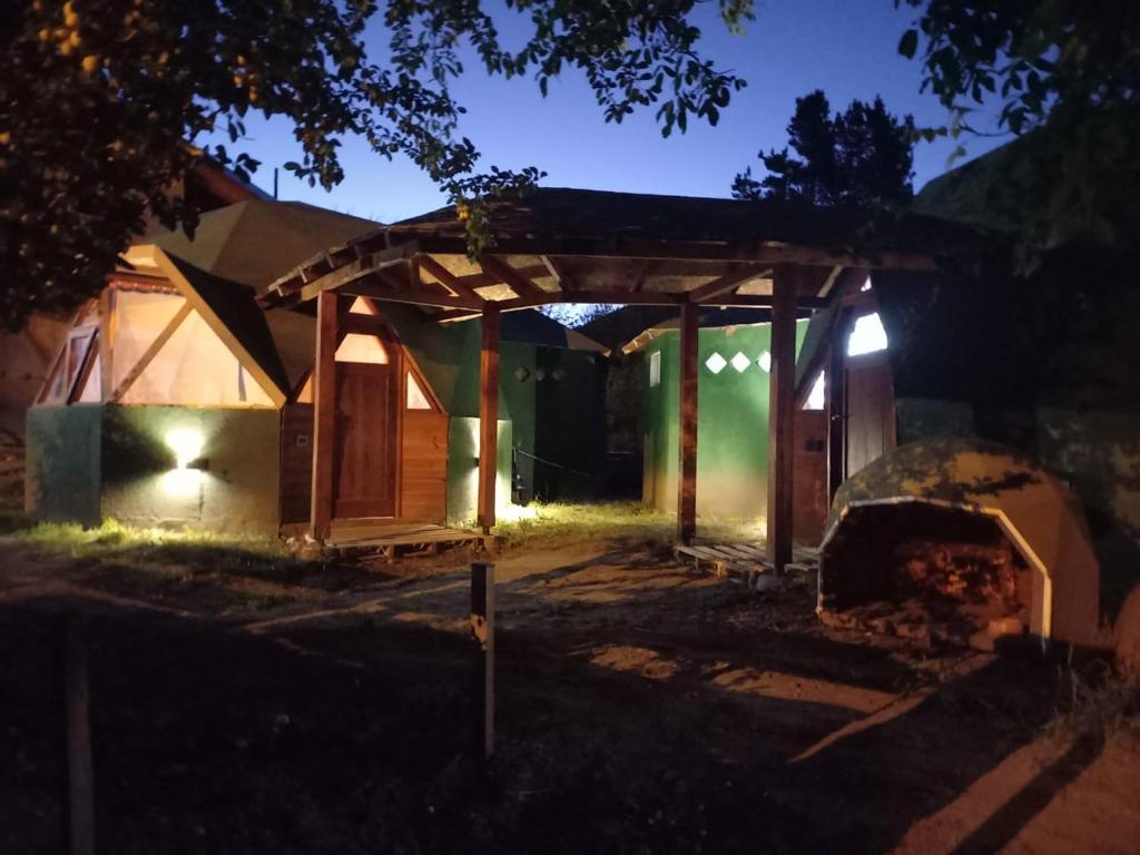 uma casa iluminada à noite com um pavilhão em Puelo EnDomos em Lago Puelo