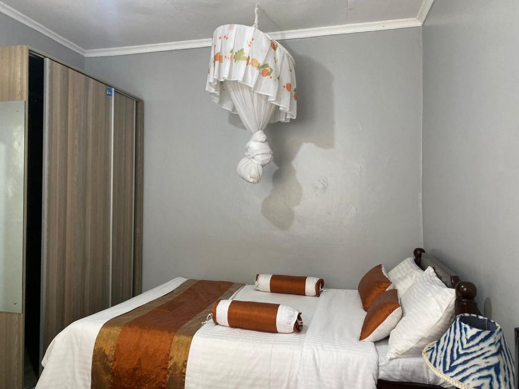 una camera con letto e lampadario a braccio di Quaint one bedroom guest house near main airport a Nairobi