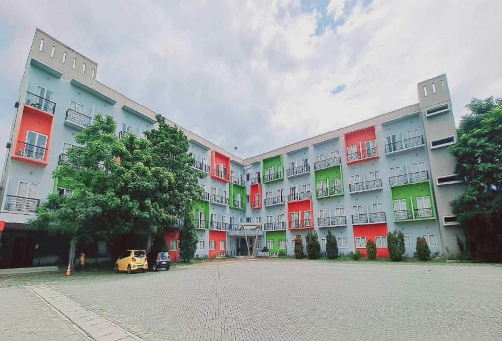 a large apartment building with red and green windows at TOS Residence Near Gading Serpong in Kampung Sawah