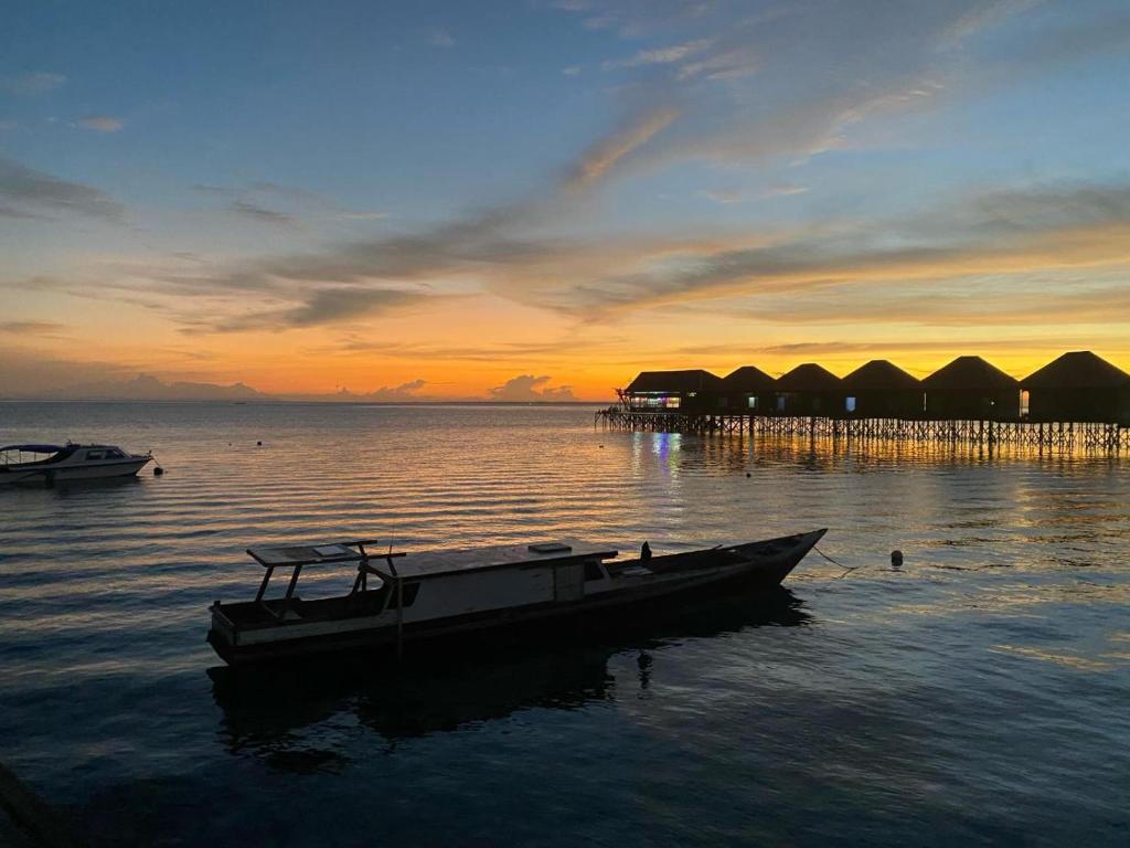 un barco sentado en el agua con un muelle en Fisheries VIP en Derawan Islands