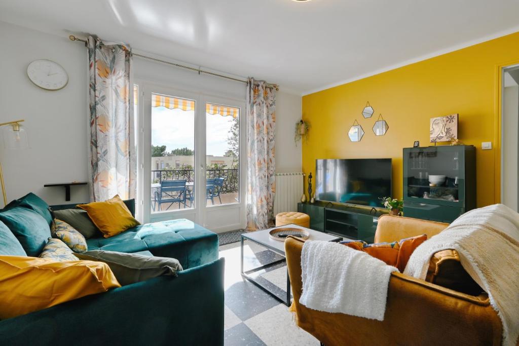 un salon avec un canapé et une télévision dans l'établissement Le Floreal - Vue mer, proche plage, parking privé, à Bandol