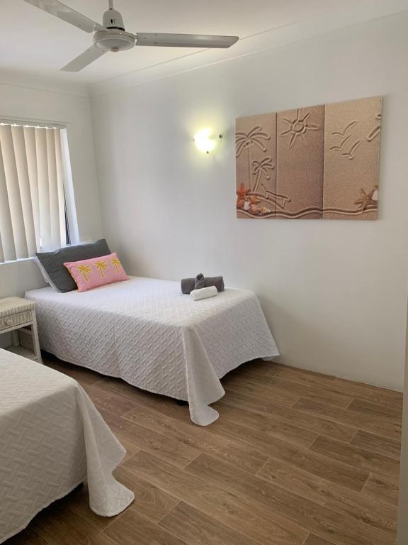 a bedroom with two beds and a painting on the wall at Beachfront at Silver Sands Hervey Bay in Hervey Bay
