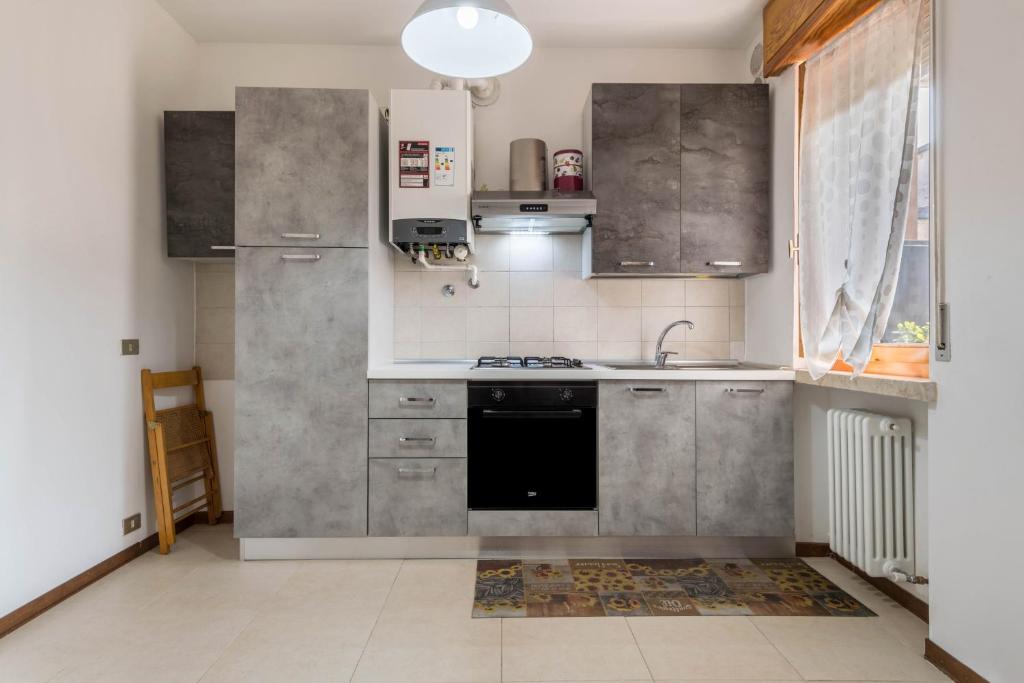 a kitchen with stainless steel cabinets and a black dishwasher at Vacanze Elma in Bussolengo
