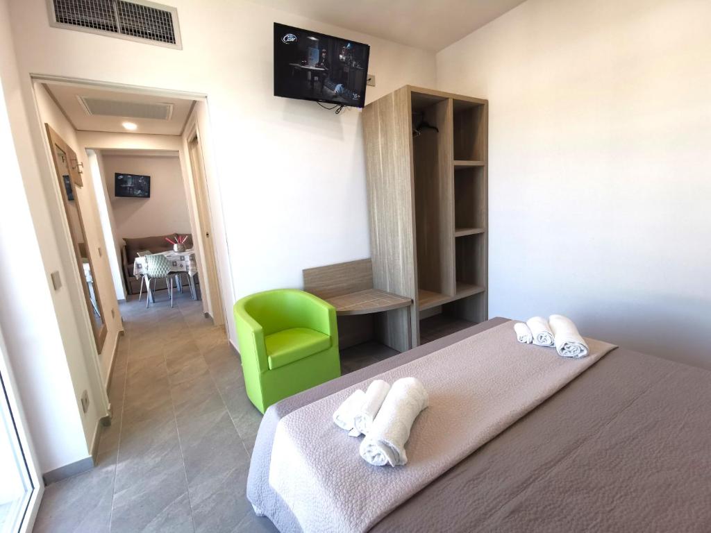 Habitación de hotel con cama y silla verde en Resort Policastro, en Policastro Bussentino