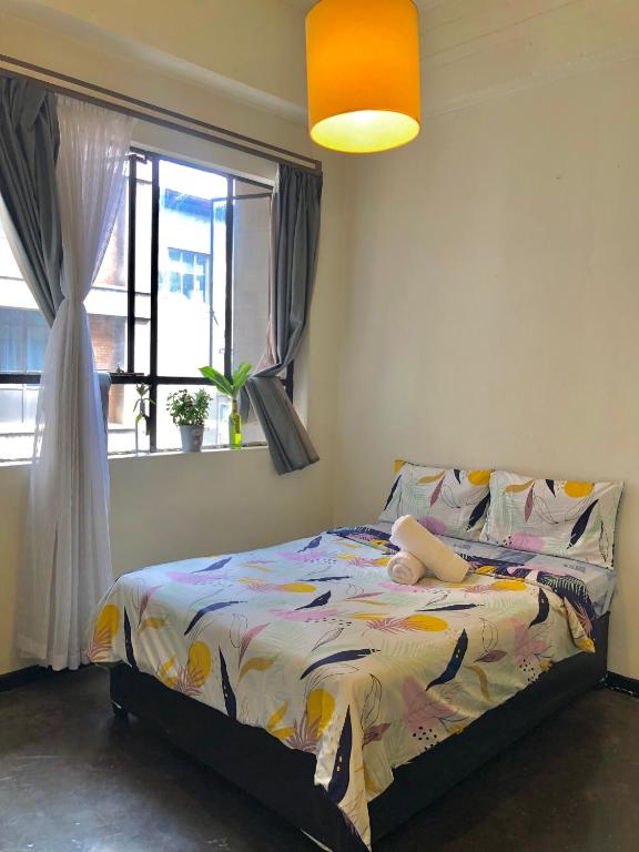 a bedroom with a bed and a window at Sun's spacious apartment in Johannesburg