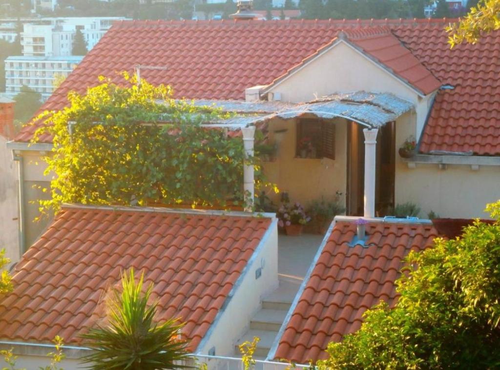 a house with red tile roofs and trees at Apartment Lukre Mala in Dubrovnik