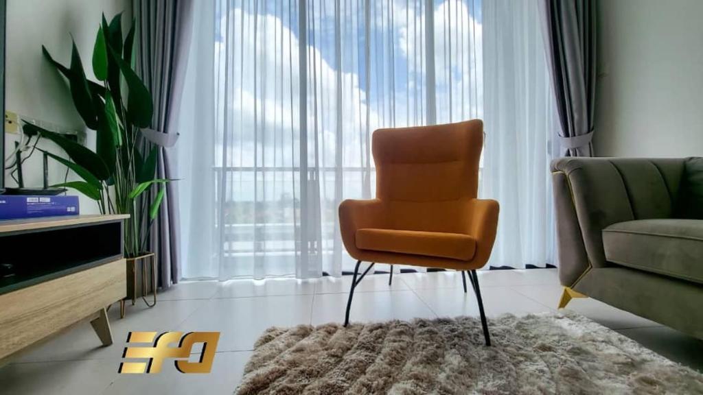 een woonkamer met een stoel en een bank bij Cozy Home at Near Centre and Airport @ Galacity in Kuching