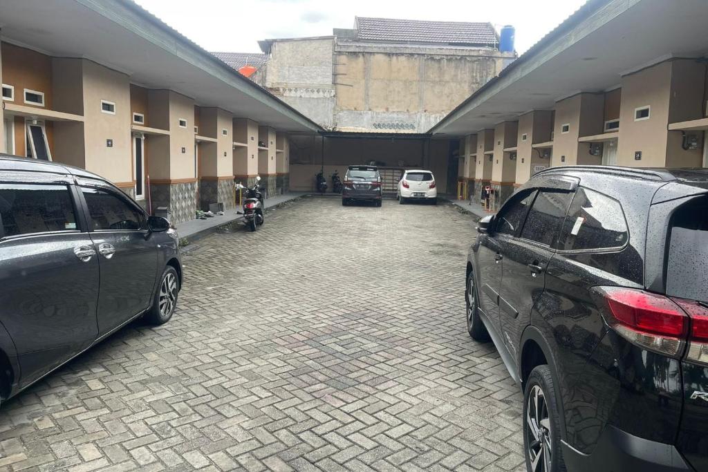 een parkeerplaats met auto's in een gebouw bij OYO 93749 Aksana Homestay Syariah in Pekanbaru