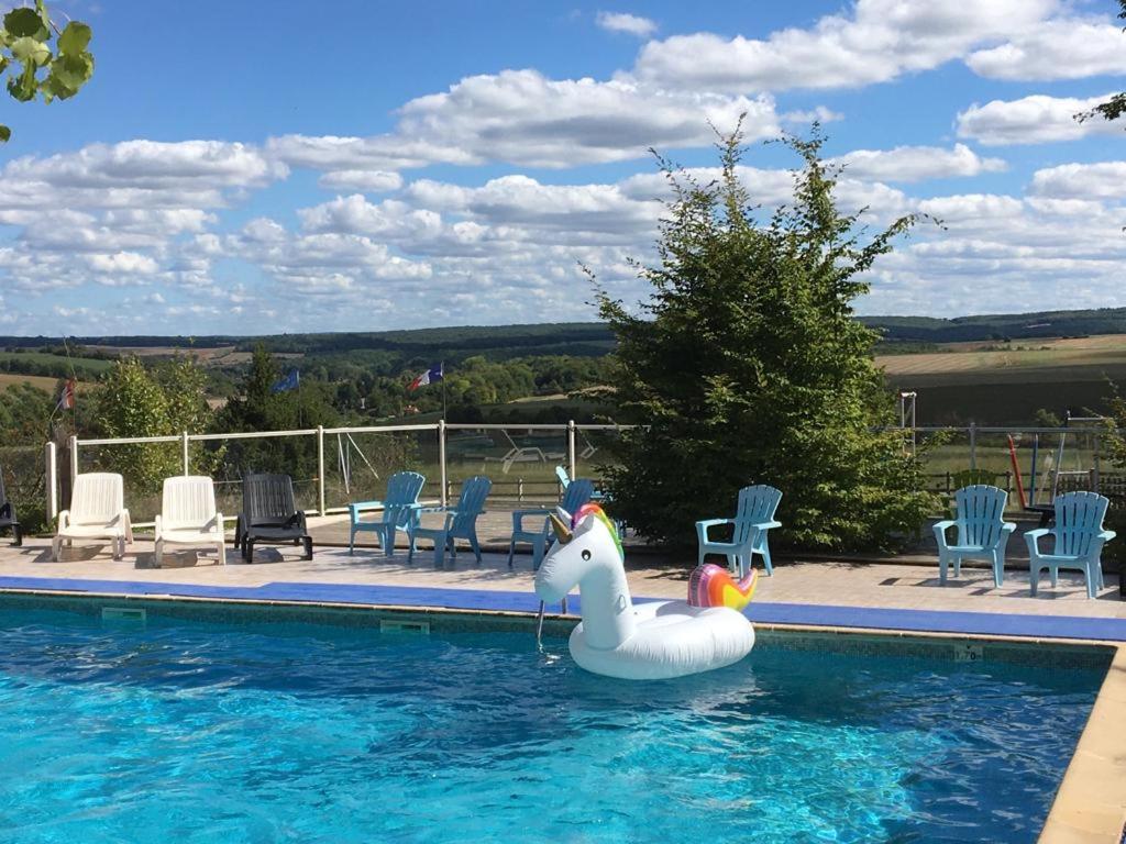 uma piscina com um cisne insuflável na água em Camping USHUAÏA Villages Au Bois Joli em Andryes