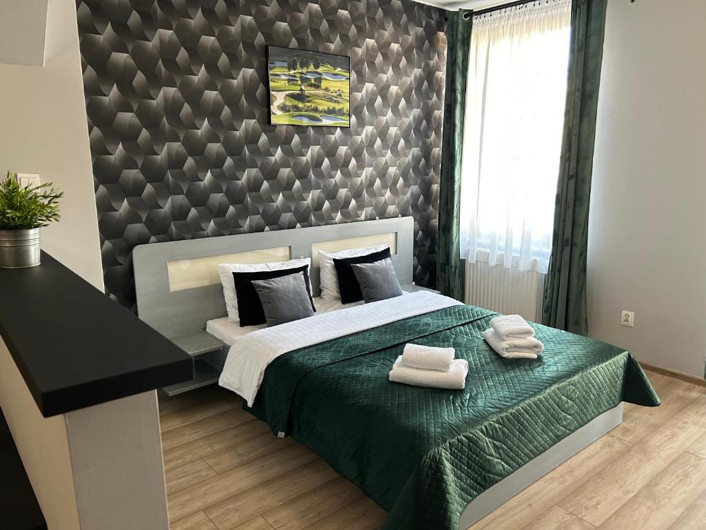 ein Schlafzimmer mit einem Bett mit zwei Handtüchern darauf in der Unterkunft H-Apartamenty Junior in Nowa Sól