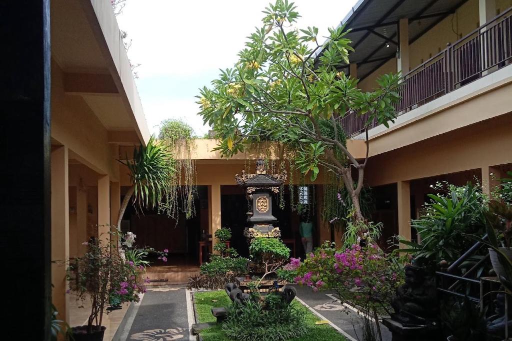 a courtyard with a clock in the middle of a building at OYO 93759 Yume Guest House in Midang