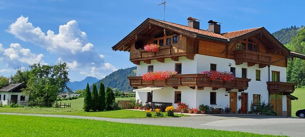 a house with flowers on the front of it at BIO- Bauernhof Obermaurach in Walchsee