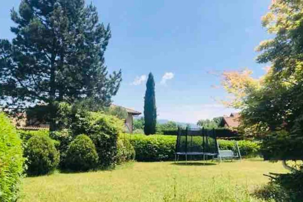einen Garten mit einer Schaukel in der Mitte eines Gartens in der Unterkunft Red Rose of Summer Flat with private garden - Wilena Holiday Home in Chens-sur-Léman
