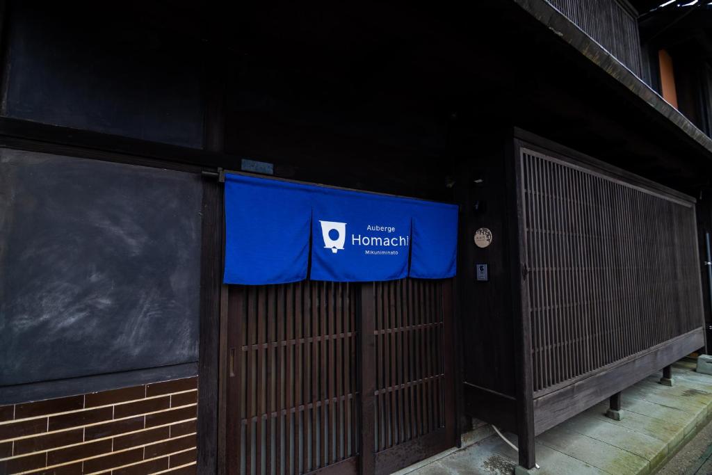 a blue sign on the side of a building at Auberge Homachi Mikuniminato in Sakai