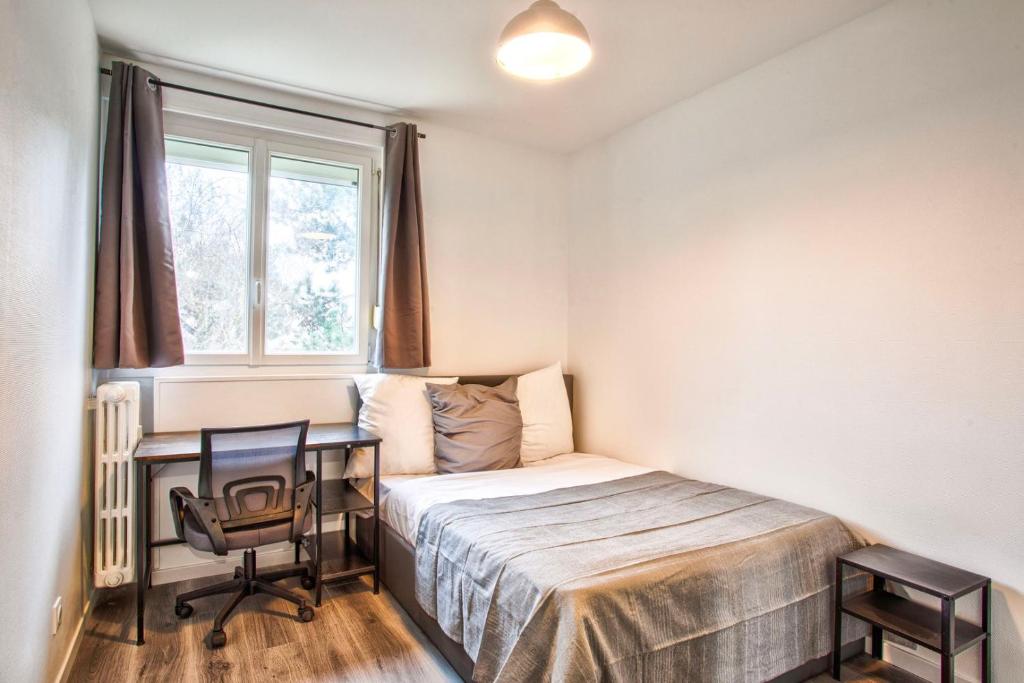 a bedroom with a bed and a desk and a window at La Casa Will - Family flat for 8 in Hérouville-Saint-Clair