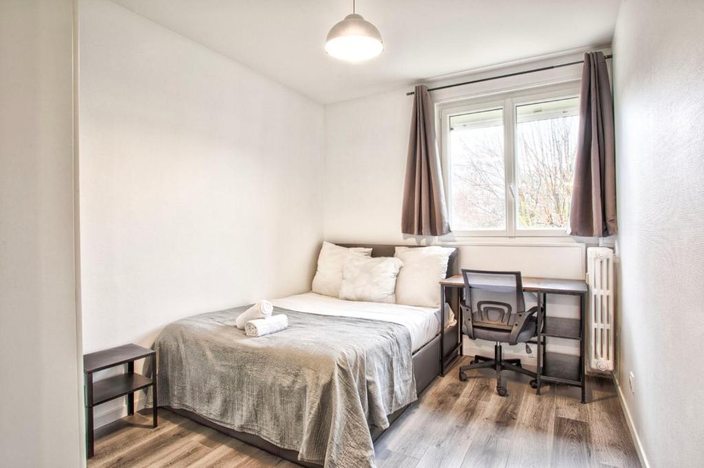 a bedroom with a bed and a desk and a window at La Casa Will - Family flat for 8 in Hérouville-Saint-Clair