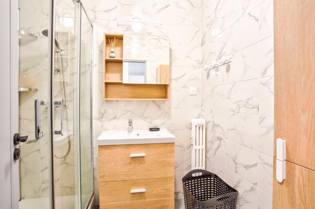 a bathroom with a sink and a glass shower at La Casa Will - Family flat for 8 in Hérouville-Saint-Clair