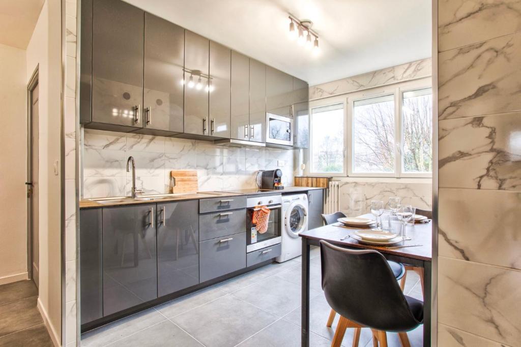 a kitchen with a table and a sink at La Casa Will - Family flat for 8 in Hérouville-Saint-Clair
