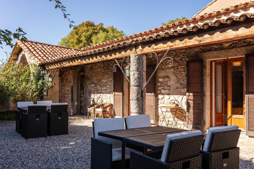 a table and chairs in front of a house at Le Barry du Grand Chemin in Le Caylar