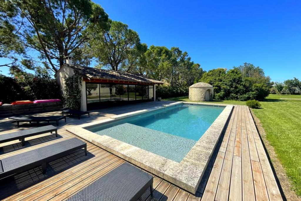 uma piscina com um deque e um gazebo em Beautiful contemporary villa swimming pool and large garden em Berre-lʼÉtang