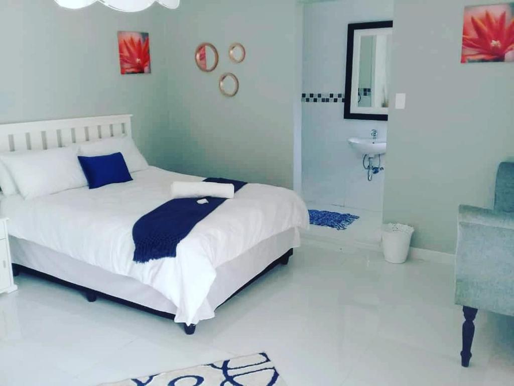 um quarto branco com uma cama e um lavatório em LeadingFarm em Margate